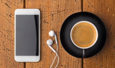 Hareket eden telefon ve kulaklık ile kahve fincanı üstten görünüm Rusti'yi üzerinde