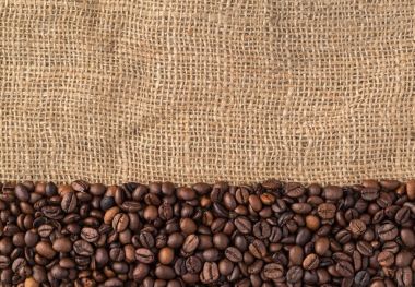 Kahve çekirdekleri doğal jüt arka planda, üstten görünüm.