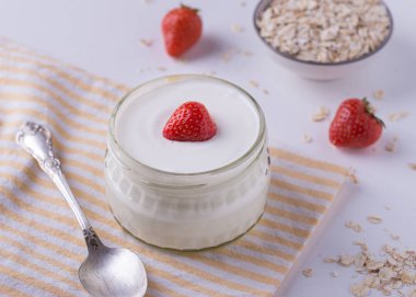 Cam kase kaşık ve starwberries beyaz arka plan üzerinde beyaz yoğurt.