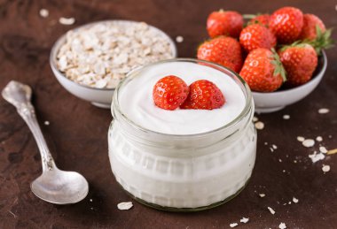 Cam kase kaşık ve starwberries rustik arka plan üzerinde beyaz yoğurt.