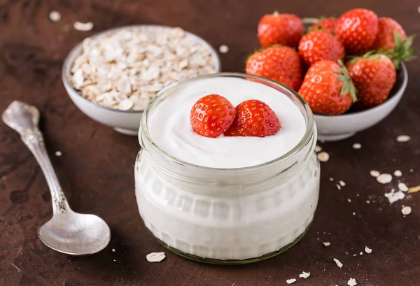 Cam kase kaşık ve starwberries rustik arka plan üzerinde beyaz yoğurt.