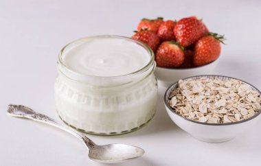 Cam kase kaşık ve starwberries beyaz arka plan üzerinde beyaz yoğurt.
