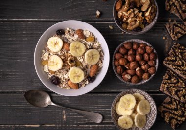 Gri doğal masa ile fındık ve muz çevresinde beyaz kase müsli ile Kahvaltı.