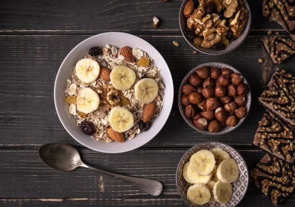 Gri doğal masa ile fındık ve muz çevresinde beyaz kase müsli ile Kahvaltı.