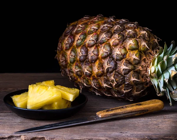 Piña en rodajas sobre escritorio rústico viejo Fondo negro . —  Fotos de Stock