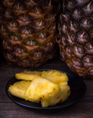 Köy masa üzerinde dilimlenmiş ananas Siyah arka plan.