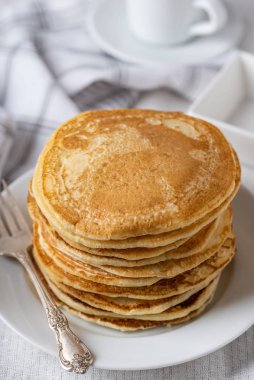 Beyaz tabakta ev yapımı krep, çatallı sol tarafta..