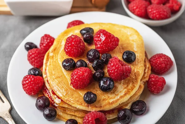 Sweet homemade pancakes with raspberries and blueberries on whit — Stock Photo, Image