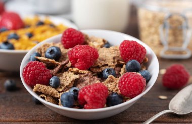 Sağlıklı kahvaltıda yaban mersini ve çilekli granola cipsi.