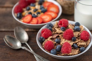 Böğürtlenli granola cipsi ve beyaz kasede ahududu..