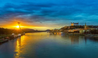 Bratislava kalesi ve restoranı bulutlu bir havada gün batımında.
