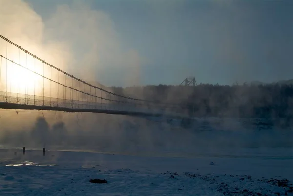 Ponte de madeira sobre o rio com neve — Fotografia de Stock