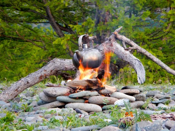 Chaleira aquecida em uma fogueira com bacground floresta verde — Fotografia de Stock