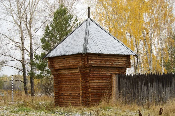 Das Holzhaus auf dem Hintergrund des Herbstwaldes — Stockfoto