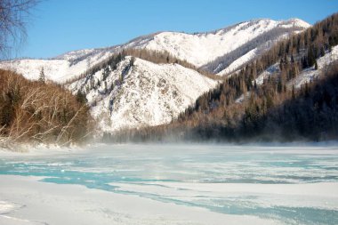 Güzel kış manzarası kar ile kaplı ağaçlar ve mavi nehir