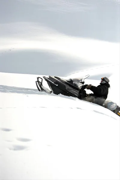 Homem dirigindo esportes snowmobile em um dia ensolarado — Fotografia de Stock