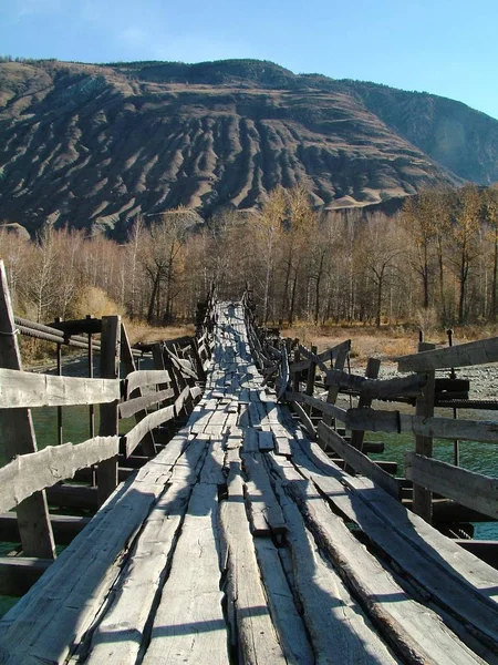 Старый деревянный мост через реку в горах — стоковое фото