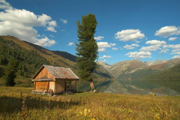 Casa solitaria de madera en las montañas cerca del lago Imagen De Stock