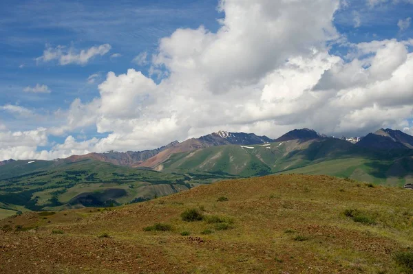 Vackra soliga dalen mellan bergen med lummiga moln — Stockfoto