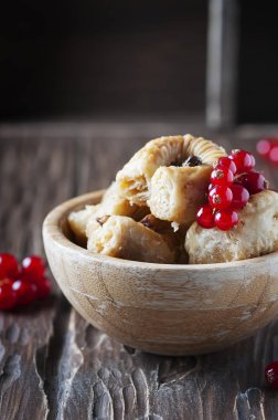 Ahşap masa üzerinde kırmızı kuş üzümü ile baklava