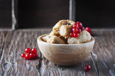 Ahşap masa üzerinde kırmızı kuş üzümü ile baklava