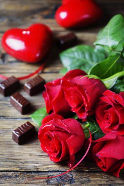 Kırmızı gül, kalp, ahşap arka plan üzerinde çikolata şekerleme ile kompozisyon