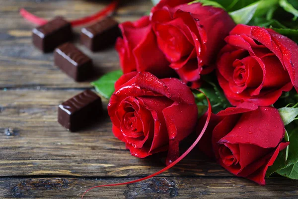 Samenstelling Met Rode Rozen Chocolade Snoepjes Houten Achtergrond — Stockfoto