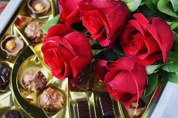 Composición Con Rosas Rojas Caramelos Chocolate Sobre Fondo Madera —  Fotos de Stock