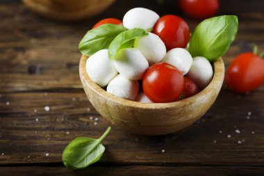 Mozzarella peyniri, domates ve fesleğen ile İtalyan meze ahşap kase hizmet