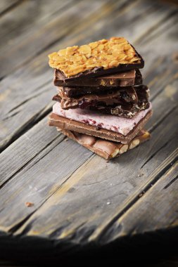 Eski püskü ahşap masa üzerinde döşeme tatlı İsviçre çikolatası karışık blokları