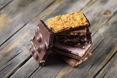 Ahşap masa üzerinde tatlı İsviçre çikolata bar karışımı