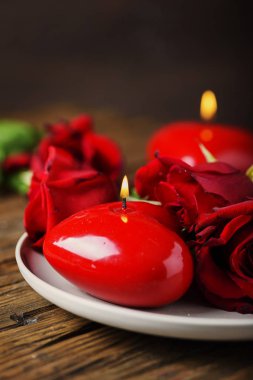 Kırmızı mumlar ve gül ahşap masa, seçici odak üzerinde