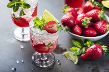 Gradient cocktail with strawberry, lime, mint and crused ice, selective focus