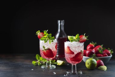 Gradient cocktail with strawberry, lime, mint and crused ice, selective focus