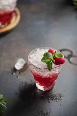 Gradient red cocktail with crushed ice, raspberry and mint, selecrive focus image
