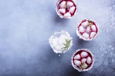 Red cocktail with ice and rosemary, selective focus image