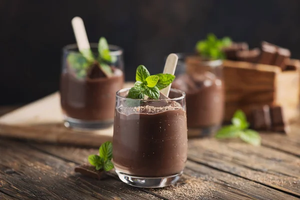 Sweet mousse with chocolate and mint on the rustic table, selective focus