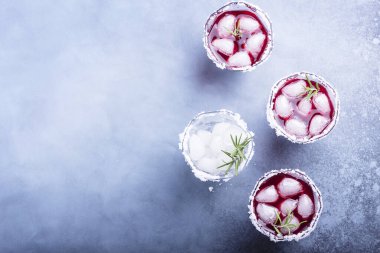 Red cocktail with ice and rosemary, selective focus image