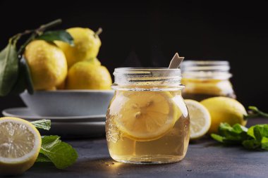 Hot lemon tea with mint on the black table, selective focus image