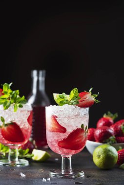 Gradient cocktail with strawberry, lime, mint and crused ice, selective focus