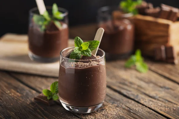 Sweet mousse with chocolate and mint on the rustic table, selective focus