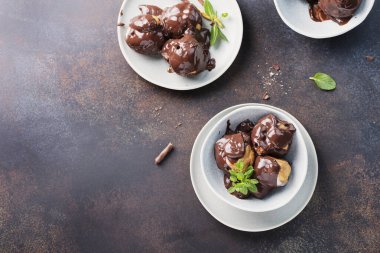 Geleneksel İtalyan tatlı profiterolleri. Çikolata kremalı, üst görüşlü ve seçici odaklı.