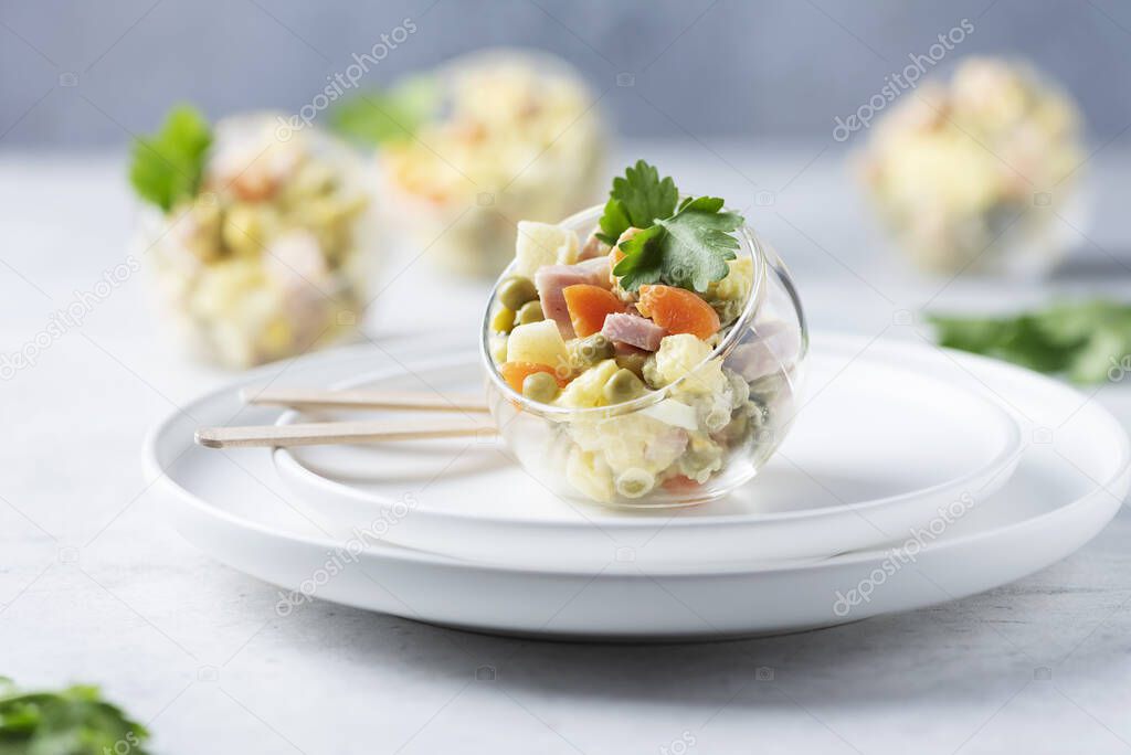 Traditional Russian salad Olivier with vegetables, ham and mayonnaise, selective focus image