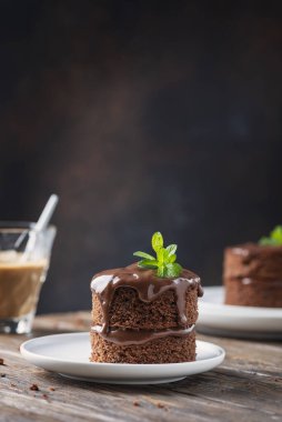 Tahta masadaki çikolatalı mini pasta, seçici odaklı resim.