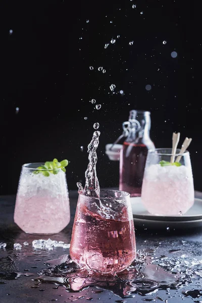 Splash of a pink cocktail on the black background, selective focus image
