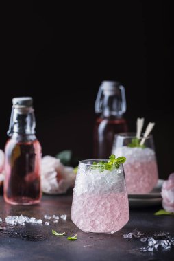 Nane aromalı pembe kokteyl ve siyah arka planda ezilmiş, seçici odaklı resim.