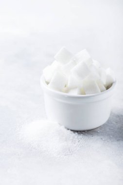 Tje hafif arka planda şeker küpleri ve şeker tanecikleri, seçici odaklanma