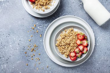 Sağlıklı kahvaltı kavramı granola, çilek ve sütle. Metin için kopyalama alanı olan en üst görüntü.