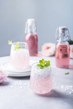 Ezilmiş buzlu pembe kokteyl ve açık arkaplanda nane, seçici odak görüntüsü