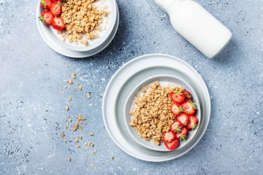 Sağlıklı kahvaltı kavramı granola, çilek ve sütle. Metin için kopyalama alanı olan en üst görüntü.